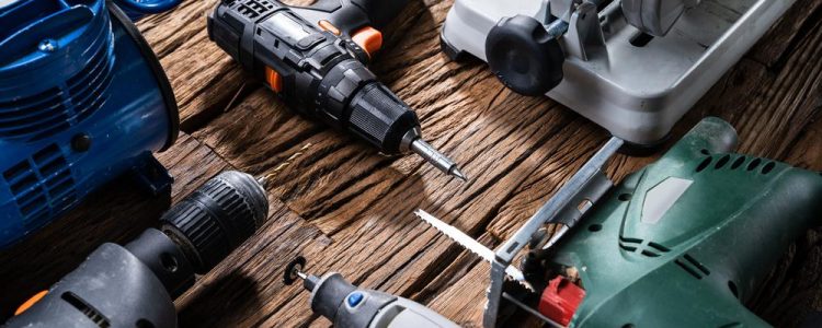 Various Power Tools Laying On Wooden Desk